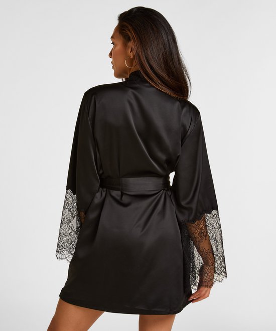 Model met lang bruin haar, achterkant van zwarte satijnen kimono met kanten mouwen