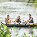 Drie mensen in een blauwe Intex Challenger 3 boot met gele accenten, op het water.
