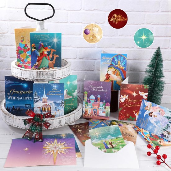Presentatie van kerstkaarten met religieuze taferelen en sterren op een witte houten etagère met kerstboom.