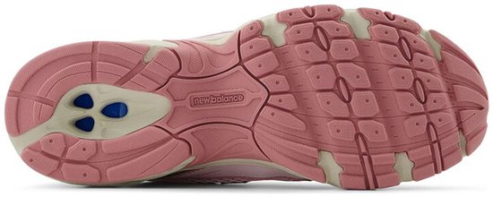 Zool van een lichtroze New Balance sneaker met beige en roze delen.
