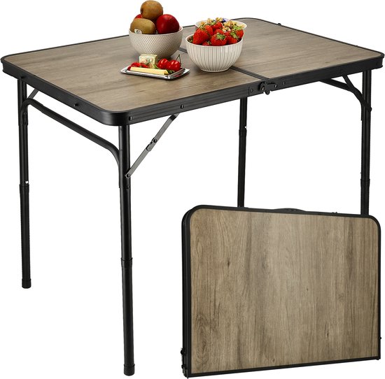 Uitgeklapte houtlook campingtafel met stoelen en fruit, met een opgevouwen tafel ernaast.