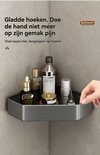 Grijze hoekdouchebak met verzorgingsproducten, gladde hoeken en een hand die het product raakt.