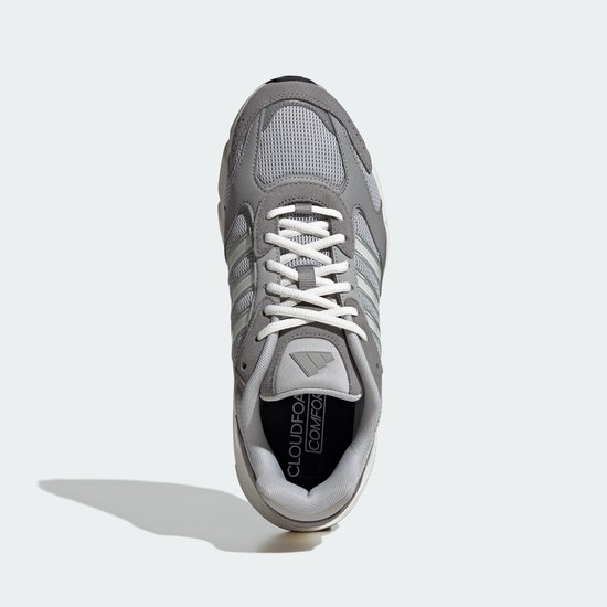 Bovenkant van een grijze Adidas sneaker met witte veters.