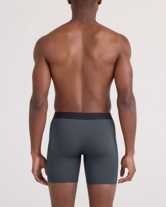 Man van achteren gezien die een grijze boxershort met rode en zwarte tailleband draagt.