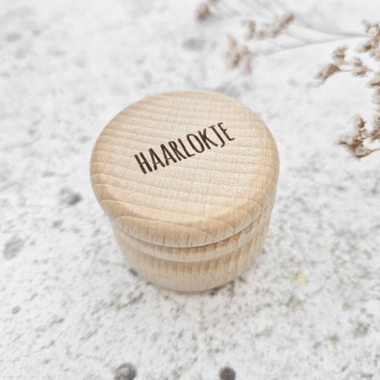 Een houten haar lokje doosje met de tekst 'HAARLOKJE' op de gesloten deksel.