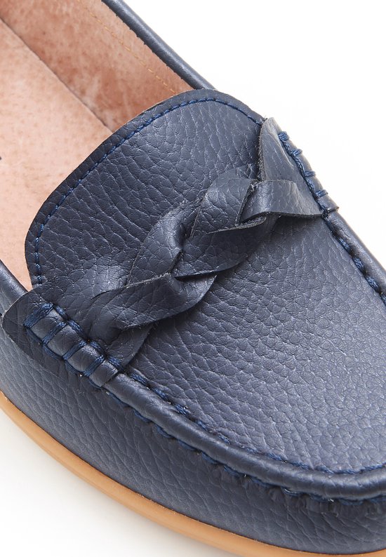 Detailopname van donkerblauwe leren mocassins met gevlochten strikdetail.