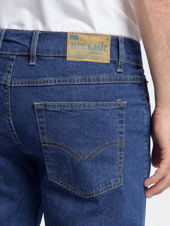Donkerblauwe spijkerbroek, achterkant met bruin label 'DJX basic'.