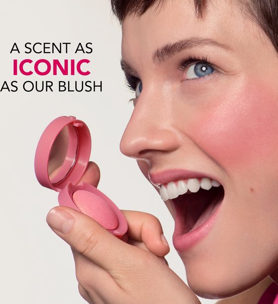 Close-up van een vrouw die een roze Bourjois Little Round Pot blush vasthoudt.