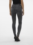 Achterkant van een model in strakke grijze jeans met hoge taille.