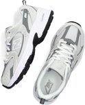 Een paar lichtgrijze New Balance sneakers met witte veters en ABZORB demping.