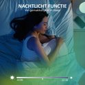 Vrouw slaapt in bed met zacht, sfeervol licht. Nachtlicht functie.