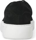 Zwarte suède sneaker met witte zool, van achteren gezien.
