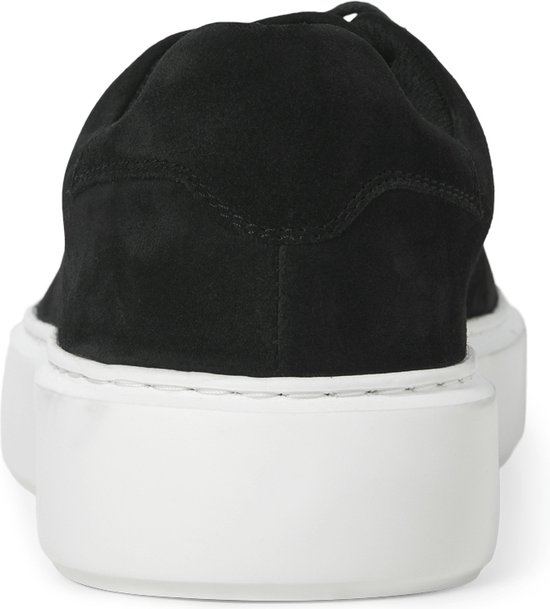 Zwarte suède sneaker met witte zool, van achteren gezien.