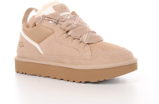 Zijzicht van een beige UGG sneaker met ruitvormige veters, wollen voering en dikke zool.