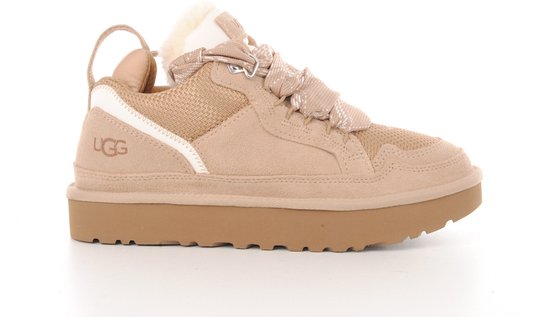 Zijzicht van een beige UGG sneaker met dikke zool, ruitvormige veters en wollen kraag.