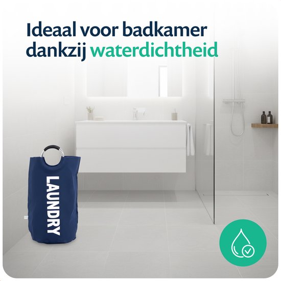 Donkerblauwe wasmand met "LAUNDRY" in witte letters, staand op de vloer in een moderne, lichte badkamer naast een douche.