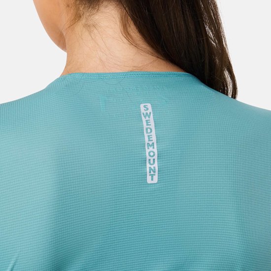 Detail van turquoise sportshirt met logo "SWEDEMOUNT" verticaal op de rug.