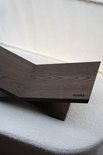 Donkerbruine eikenhouten boekenstandaard in X-vorm, met het logo 'cookx'.