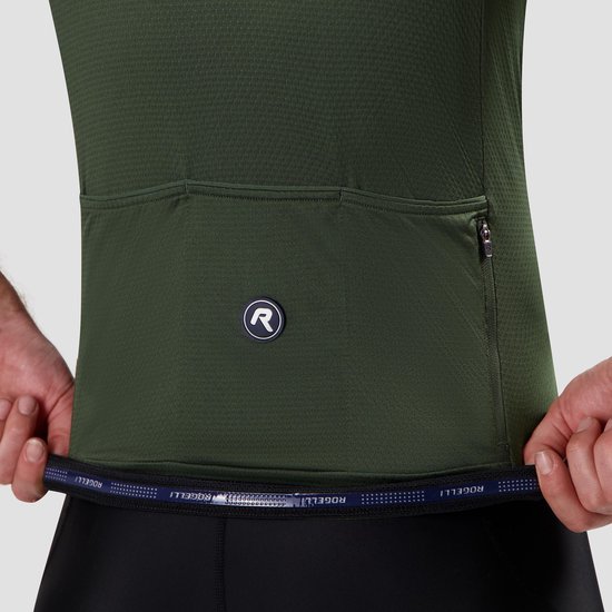 Detail van een donkergroen wielershirt met achterzakken en een gestreepte band met merknaam.