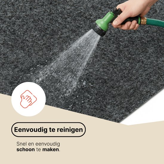Tapis gris foncé nettoyé à l'eau avec un tuyau d'arrosage, montrant le nettoyage.