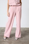 Lichtroze wijde broek met plooien aan de voorkant, gedragen met glinsterende puntige schoenen.