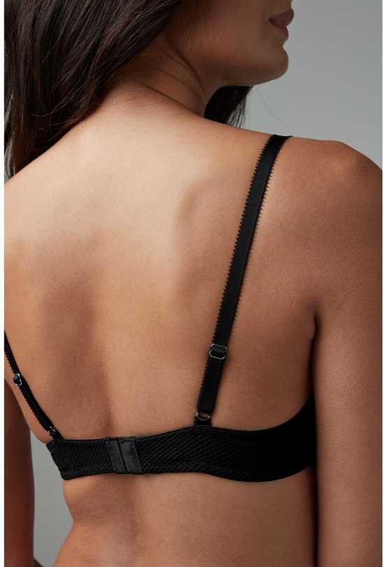 Achterkant van model in zwarte push-up beha met kanten details.