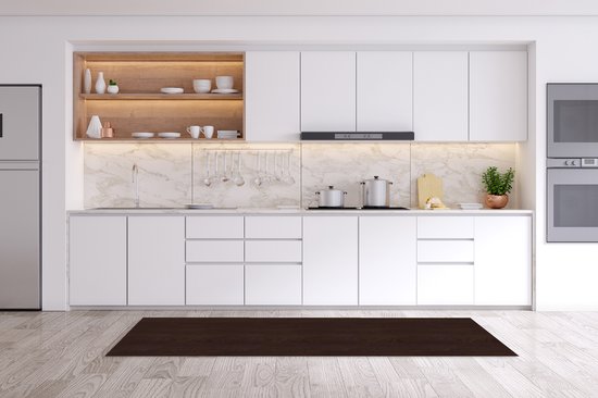 Tapis de cuisine brun foncé à motif bois de feuillus sur un plancher en bois clair devant une cuisine blanche moderne.