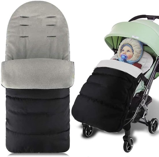 Een baby in een zwarte en grijze warme voetenzak in een kinderwagen, met een grijze kap.