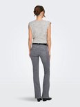 Vrouw met lichtgrijs gebreid vest met schoudervulling en lichtgrijze flared jeans.
