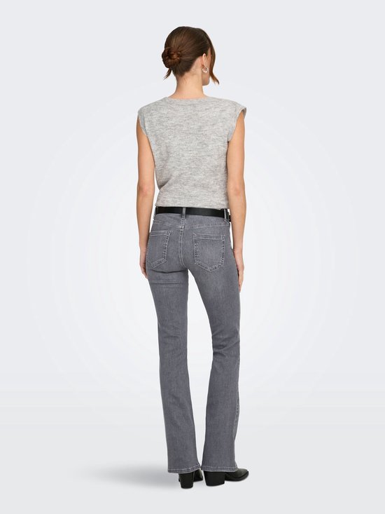 Vrouw met lichtgrijs gebreid vest met schoudervulling en lichtgrijze flared jeans.