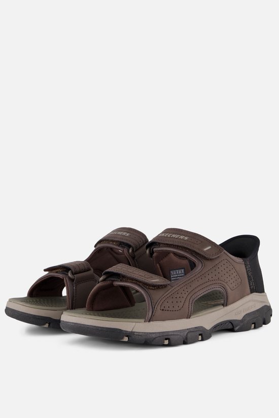 Paar bruine Skechers 'Slip-Ins' sandalen, zij-aanzicht, met klittenbandsluiting.
