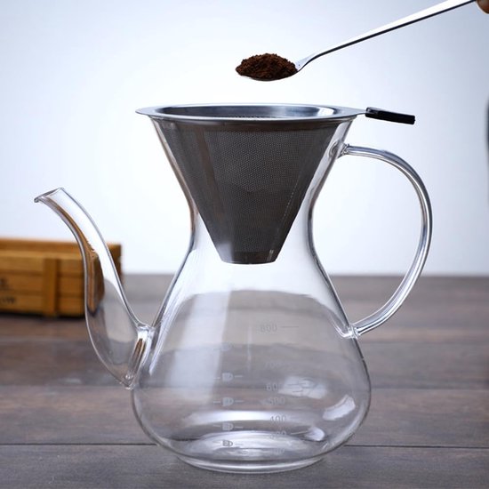 Glazen koffiezetapparaat met zilverkleurig RVS filter, er wordt koffiepoeder in geschept.