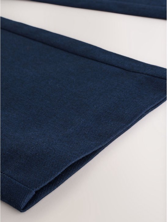 Donkerblauwe stof van een rechte broek met een nette zoom.