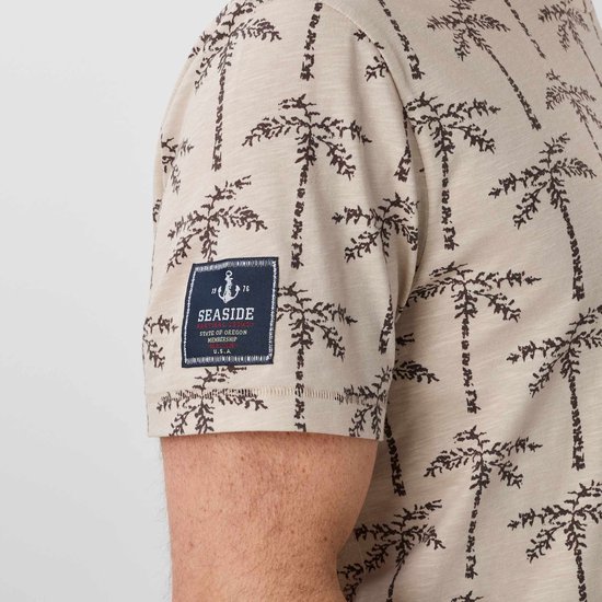Detail van beige T-shirt met palmbomenprint en 'Seaside State of Oregon Membership' patch op de mouw.