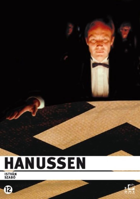 Man in smoking met strikje, legt hand op een kist met zwart-gouden zigzagpatroon. Titel: Hanussen.