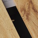 Close-up van de verbinding van de houten tafelbladen met metalen sluitingen.