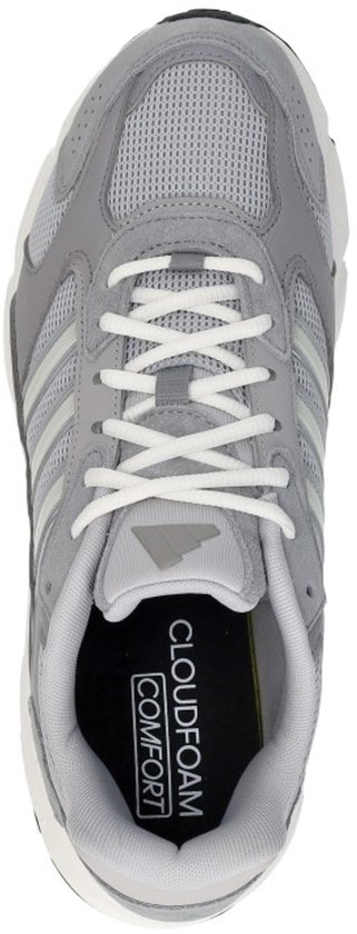 Bovenkant van een grijze Adidas sneaker met witte veters en lichtgroene strepen.