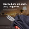 Hand die G4 lamp vasthoudt met een donkere doek, met onscherpe lampen op achtergrond.