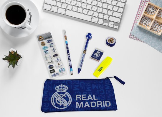 Real Madrid etui, pen, potlood, stickers, gum, markeerstift en rolletje tape met clublogo's, op bureau met toetsenbord en mok.