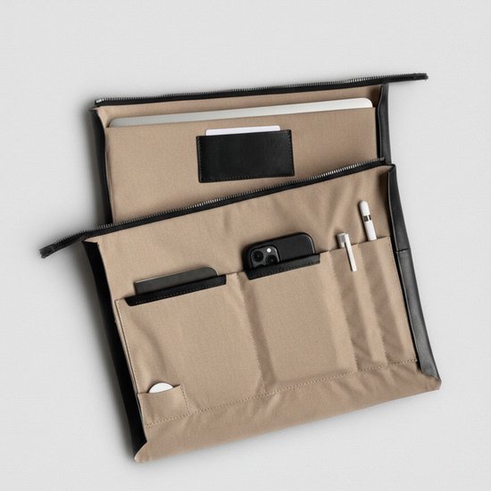 Open cognac leren laptoptas met zwarte voering, laptop, telefoon, pennen en vakjes.