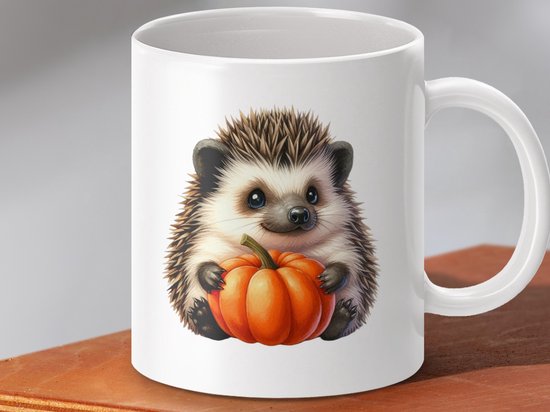 Witte mok met schattige egel die een pompoen vasthoudt, op een houten ondergrond.