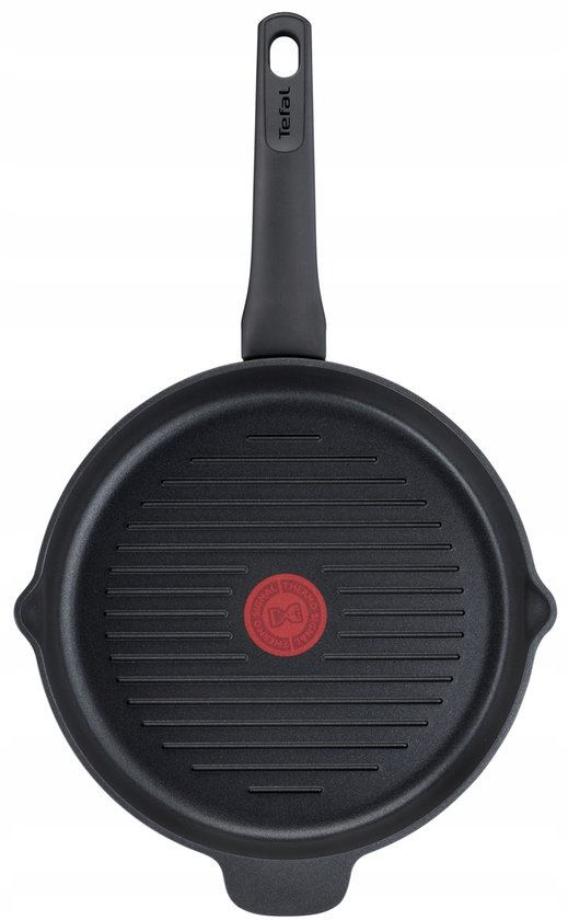 Een zwarte Tefal grillpan, bovenkant, met geribbelde bodem en rode indicator.