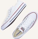 Twee witte lage Converse sneakers, een van de zijkant, een van boven.