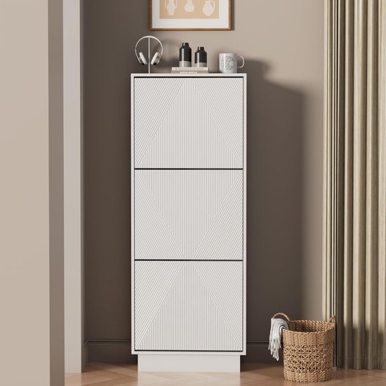 Gesloten witte schoenenkast met 3 kleppen, met lijnpatroon. Bovenop staan decoraties. Naast de kast een mand.