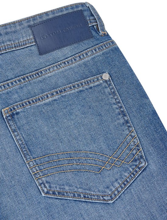 Achterkant van een blauwe jeans met een donkerblauw leren Tom Tailor label op de tailleband.