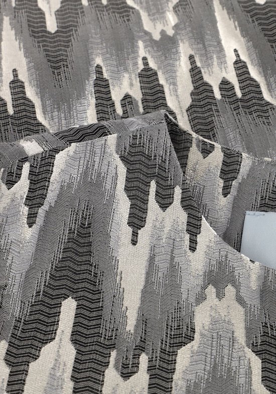Grijze stof met een zigzag patroon in verschillende grijstinten en beige.