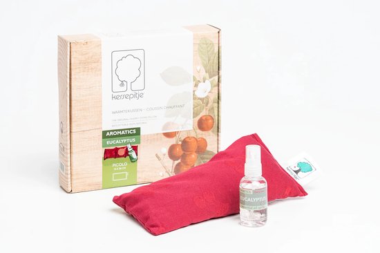 Verpakking met 'kersenpitje'-logo, tekst 'WARMTEKUSSEN' en afbeelding van kersen, naast een rood kersenpitkussen en flesje eucalyptus spray.