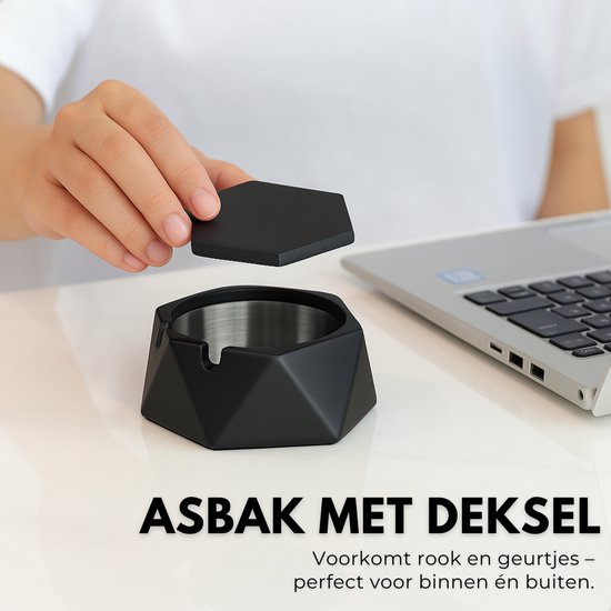 Hand plaatst zeshoekig deksel op zwarte, zeshoekige asbak met RVS binnenbak. Laptop op achtergrond.