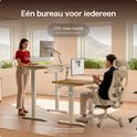 Man en vrouw aan verstelbaar massief eiken bureau in moderne kantoorruimte met grote ramen.