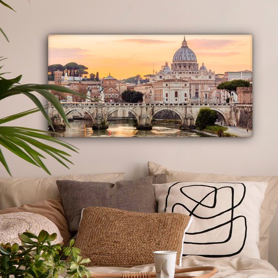 Canvas van de Sint-Pietersbasiliek en de Ponte Sant'Angelo in Rome bij zonsondergang, met warme oranje en gele tinten.